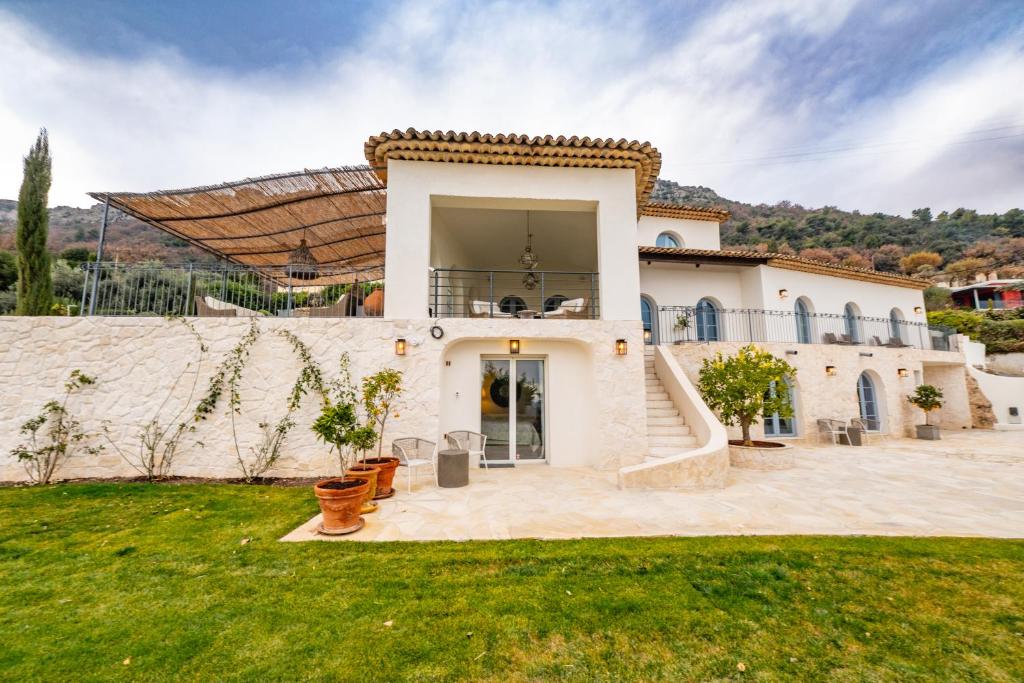 een groot wit huis met een trap in een tuin bij Villa vue panoramique proche Saint-Paul-de-Vence in Vence