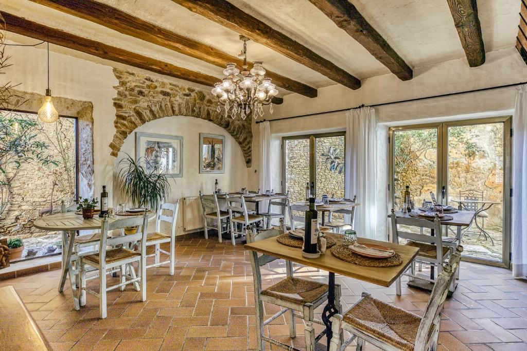 una sala da pranzo con tavoli, sedie e finestre di Can Barrull-Costa Brava-Emporda a Sant Feliu de Boada