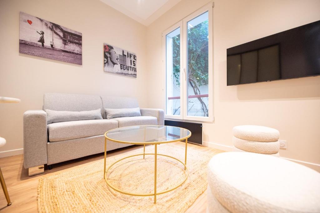 un salon avec un canapé et une table dans l'établissement CIA - Luxembourg's Garden Residence, à Paris