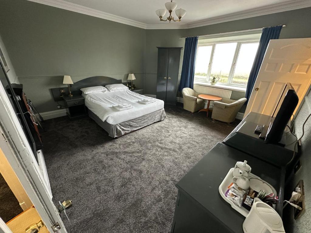 バロー・イン・ファーネスにあるClarkes Hotel Barrow in Furnessのベッドと机があるホテルの部屋