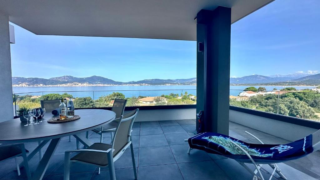 une salle à manger avec une table et des chaises et une grande fenêtre dans l'établissement Appartement vue mer panoramique & plage à pied Porticcio, à Grosseto-Prugna