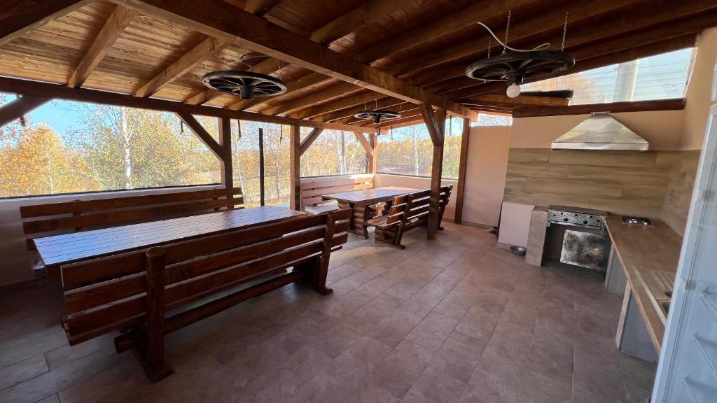 a large room with benches and a stove in a cabin at Domeniul H in Rişca