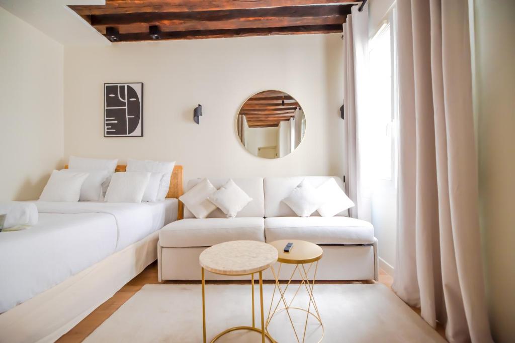 - un salon blanc avec un canapé blanc et un tabouret dans l'établissement CIA - Studio near Louvre & Tuileries, à Paris