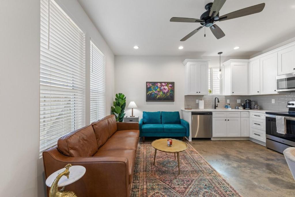 ein Wohnzimmer mit einem braunen Sofa und einem blauen Stuhl in der Unterkunft NEW Acadian House KING Bed Cajun Luxury Nespresso in Lafayette