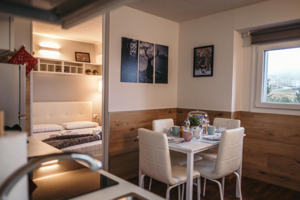 a dining room with a table and chairs and a bedroom at App Panoramico 300 mt dalle Piste Relax e Vista Alpi in Passo del Tonale