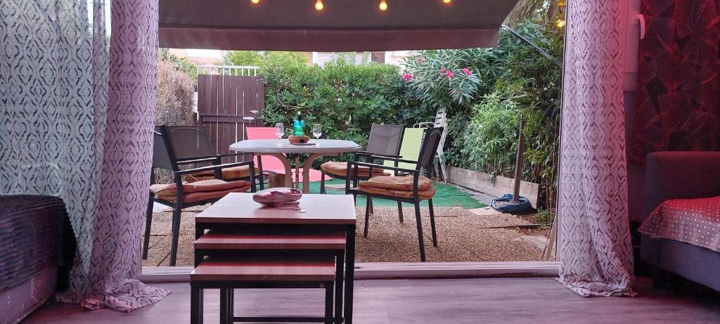 Cette chambre dispose d'une terrasse avec une table et des chaises. dans l'établissement Appartement RDJ cap d' Agde, au Cap d'Agde