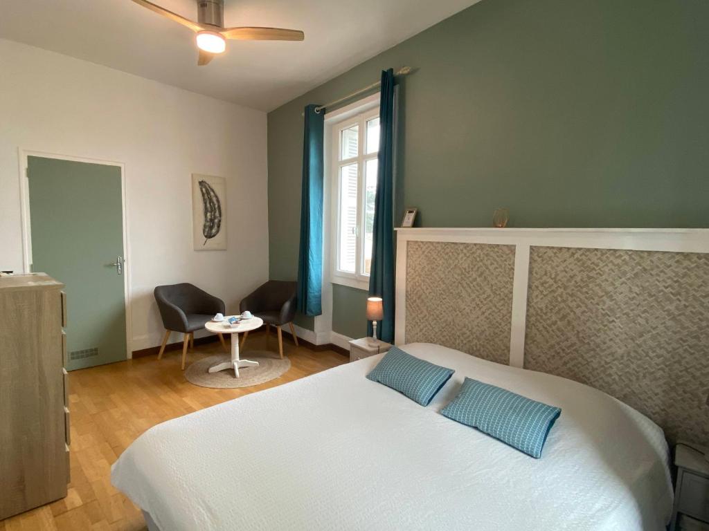 a bedroom with a large white bed with blue pillows at Les Mariniers Chambres d'Hôtes à la campagne avec aire de jeux - Spa nordique en option in Mareuil-sur-Cher