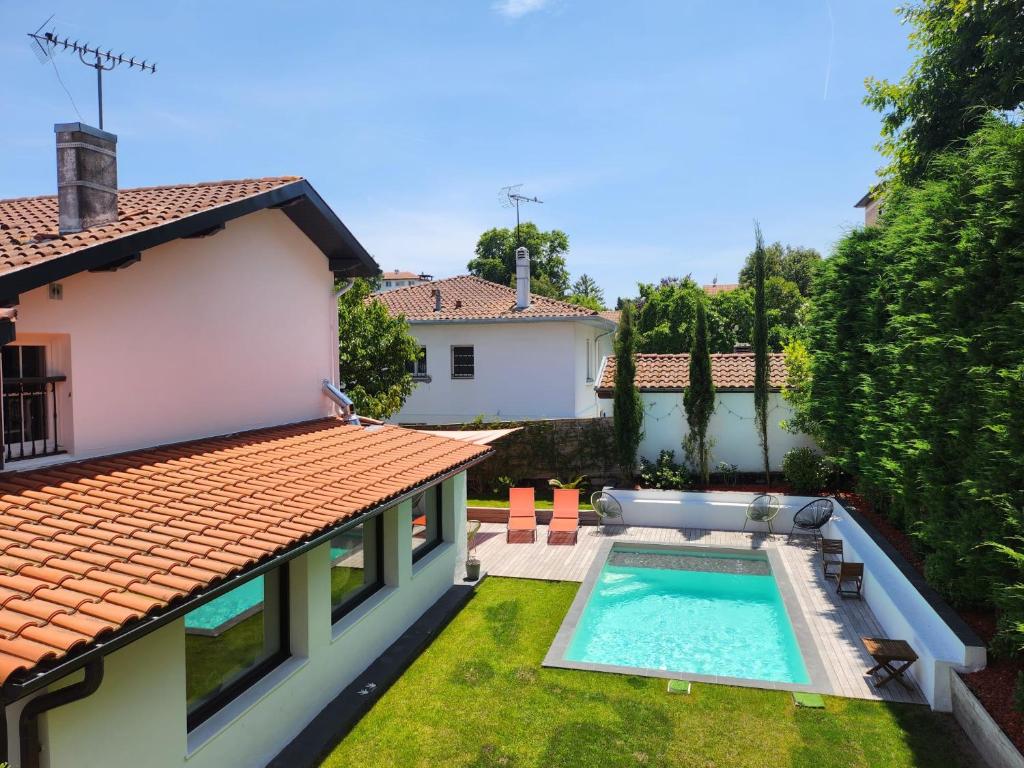 une cour arrière avec une piscine et une maison dans l'établissement Charmante maison avec piscine, à Anglet