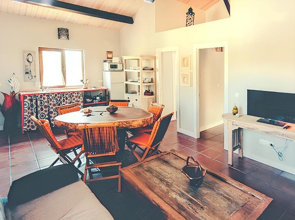 a living room with a table and chairs and a tv at Cozy house in Cañamero of 86 m² with shared pool in Cañamero