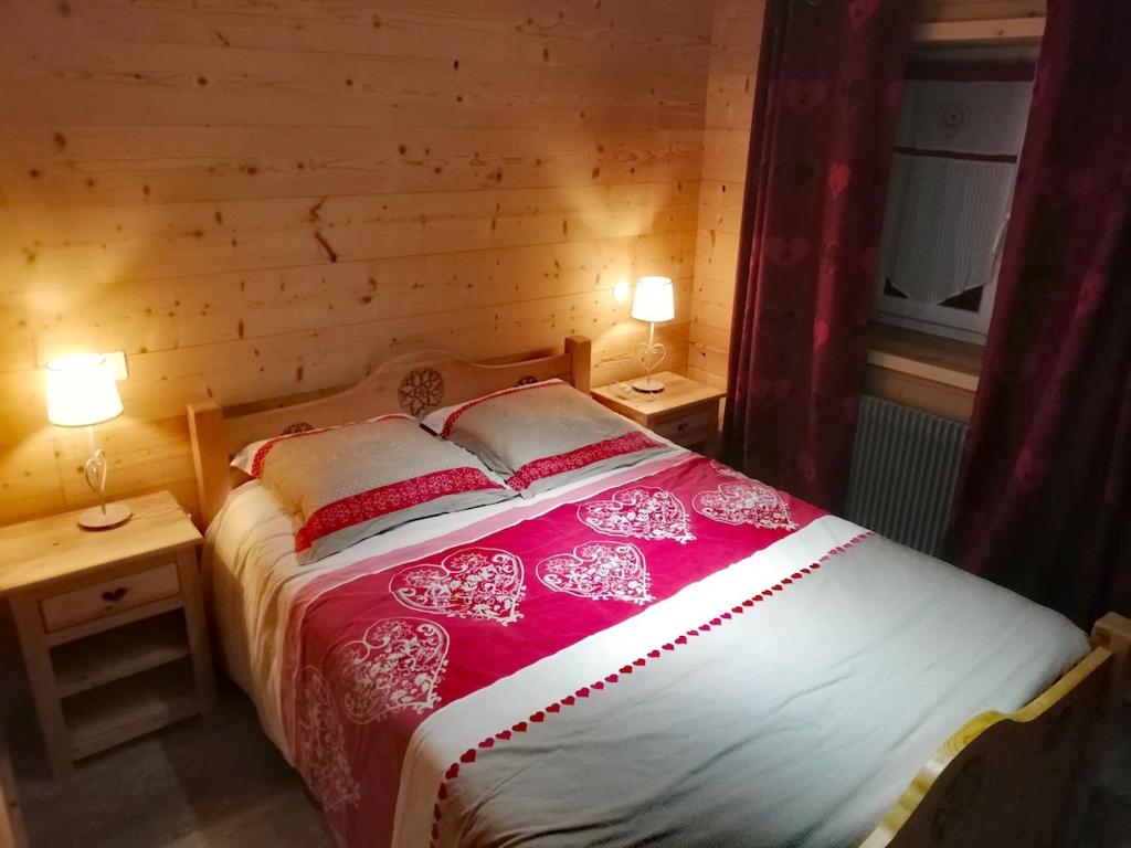une chambre avec un lit avec deux tables et deux lampes dans l'établissement logement cosy entre lac et montagnes, à Larringes