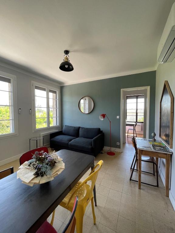 un salon avec un canapé bleu et une table dans l'établissement Le gîte de l 'instit', à Peyraud