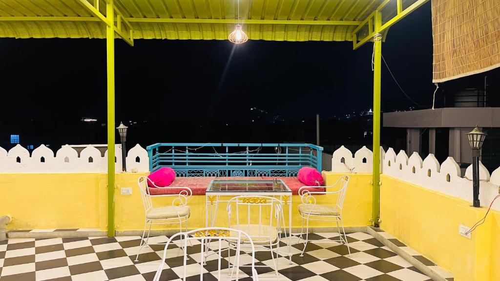 a patio with chairs and a table and a couch at Hotel Ushaan Haveli in Udaipur