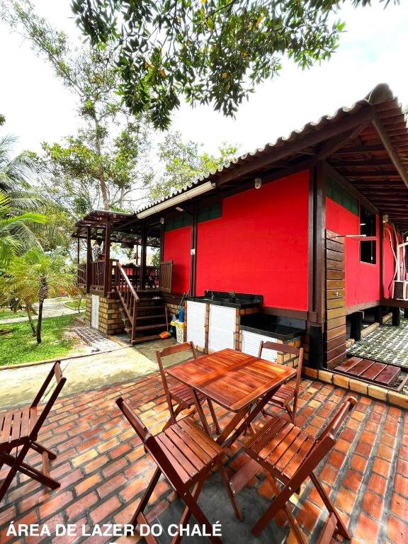 a patio with a table and chairs in front of a building at Refúgio em Barreirinhas Chalé in Barreirinhas
