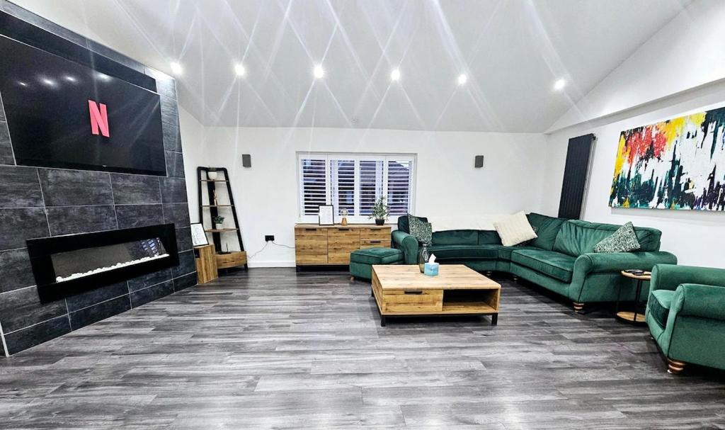 a living room with green furniture and a fireplace at The Penthouse Tamworth Spacious 3 Bedroom Apartment in the town centre in Tamworth