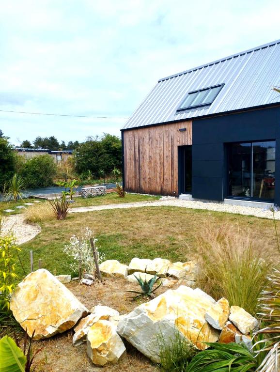 une maison avec un toit en métal et quelques pierres dans l'établissement Villa Malgira, bord de mer, à Saint-Germain-sur-Ay