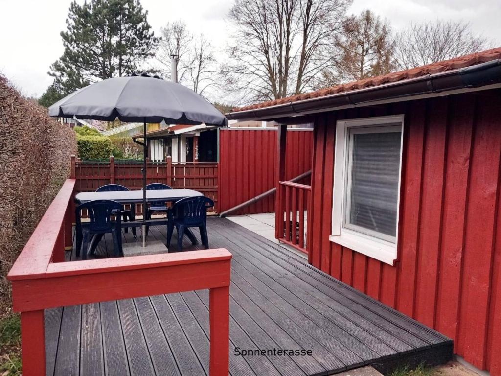 a wooden deck with a table and an umbrella at Möwe 30 in Mirow