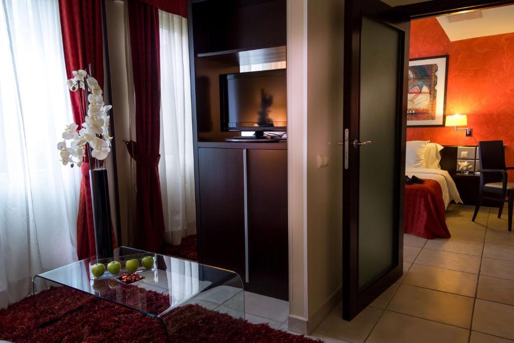 a living room with a television and a table with fruit on it at Best Western Plus Grand Hotel Victor Hugo in Luxembourg
