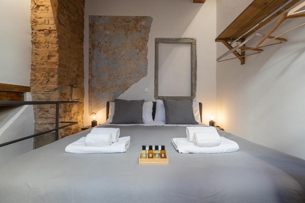 a bedroom with a bed with white towels and bottles of wine at Uffizi-Ponte Vecchio Mini Loft con affreschi in Florence