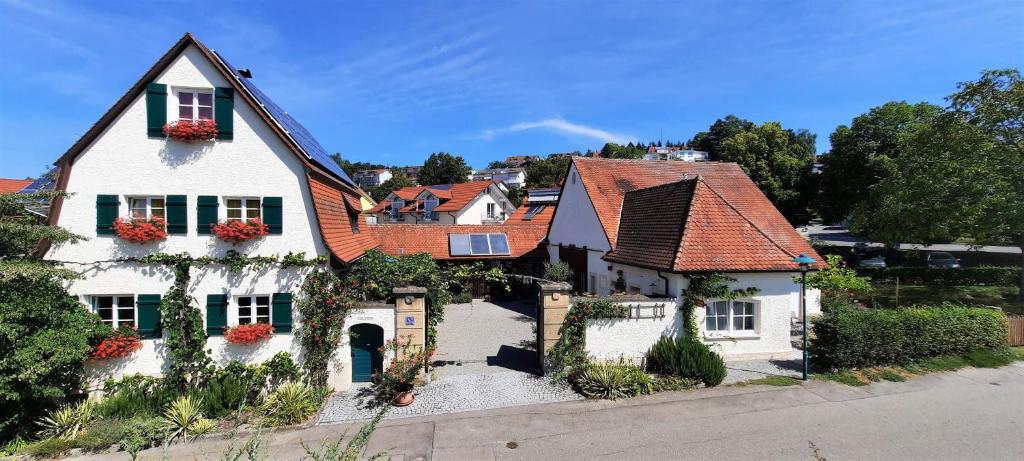 une maison blanche avec des toits rouges et des fleurs sur elle dans l'établissement Ferienscheune, à Daisendorf