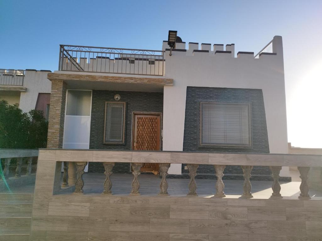 a house with a wooden deck in front of it at Palma Aglou in Tiznit