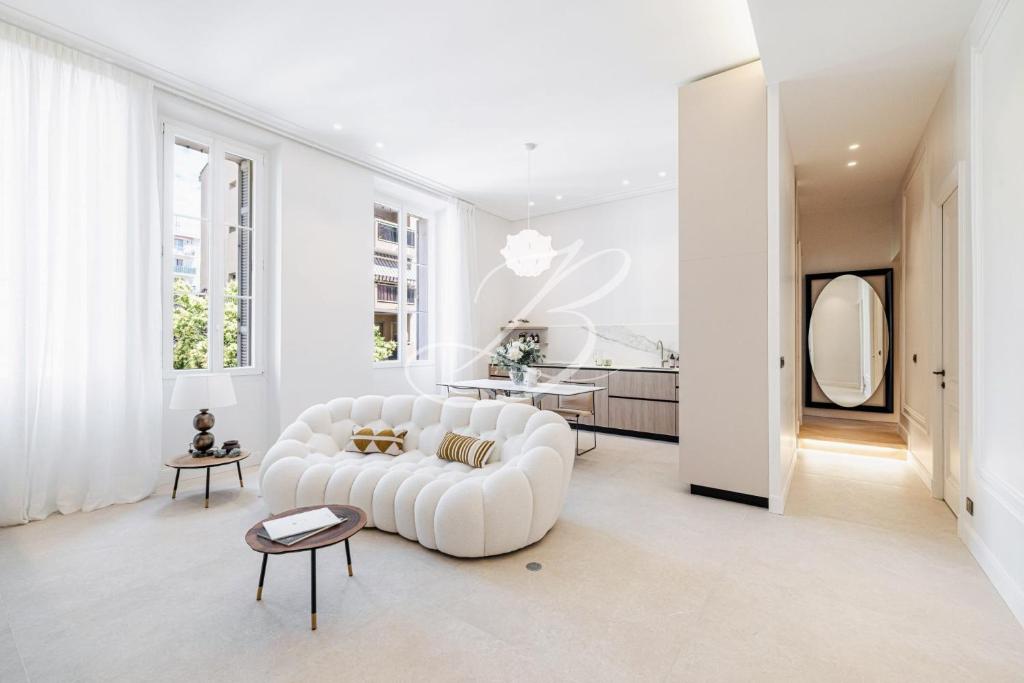 un salon avec un canapé blanc et une table dans l'établissement Le Mané - Haussmannien Centre Cannes accommodation, à Cannes