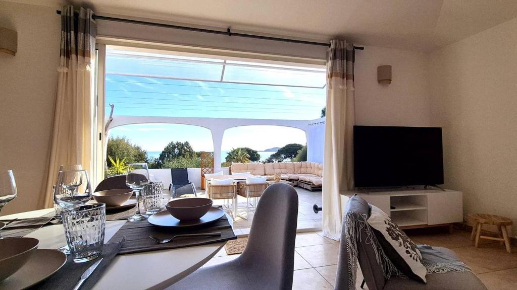 une salle à manger avec une table et une grande fenêtre dans l'établissement Appartement Ruscana, 4 pers, 90 m plage, à Pinarellu