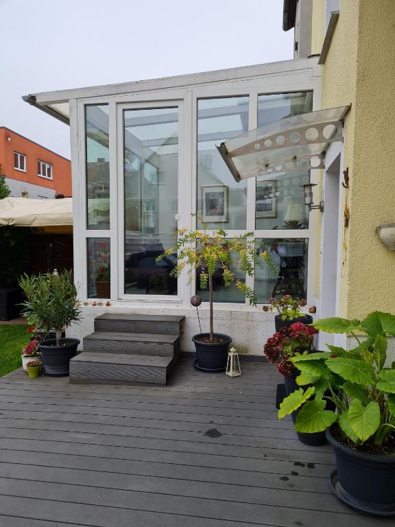 a porch with potted plants and a building at Wohnung mit Wintergarten in Rüsselsheim