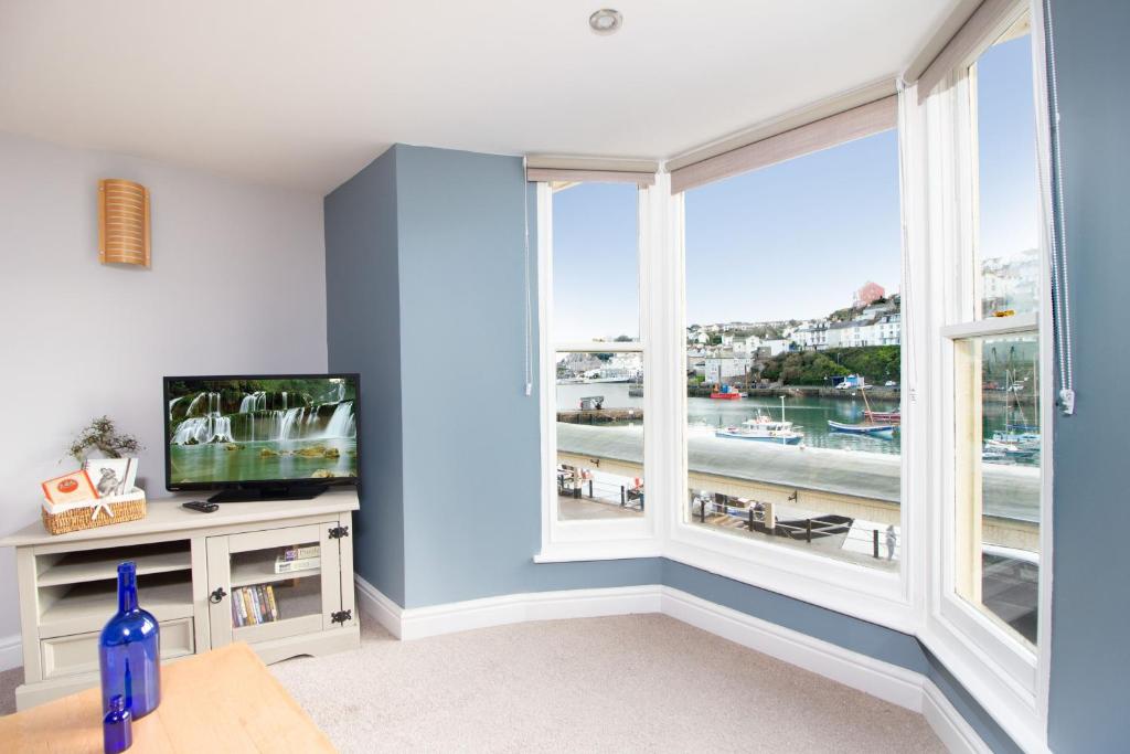 a living room with a large window and a television at High Hopes, Harbour Location with Sea Views in Brixham
