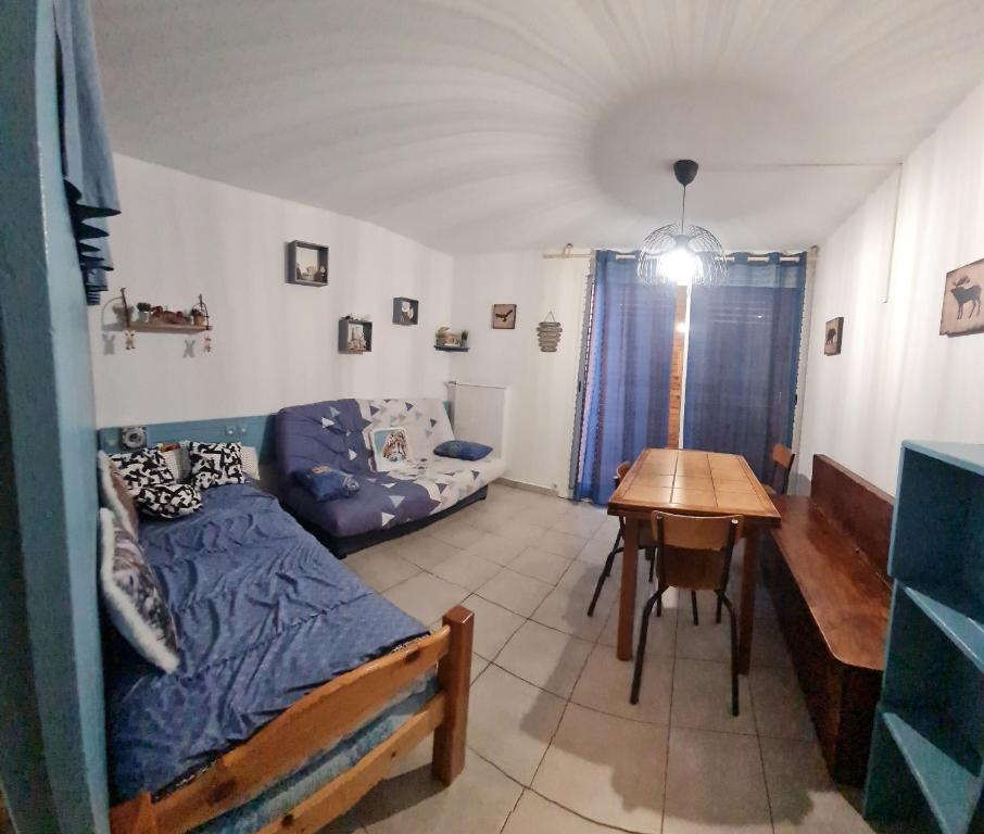 une chambre avec un lit et une table dedans dans l'établissement Pied pistes Superdévoluy 7p chez Locasoleil, à Saint-Étienne-en-Dévoluy