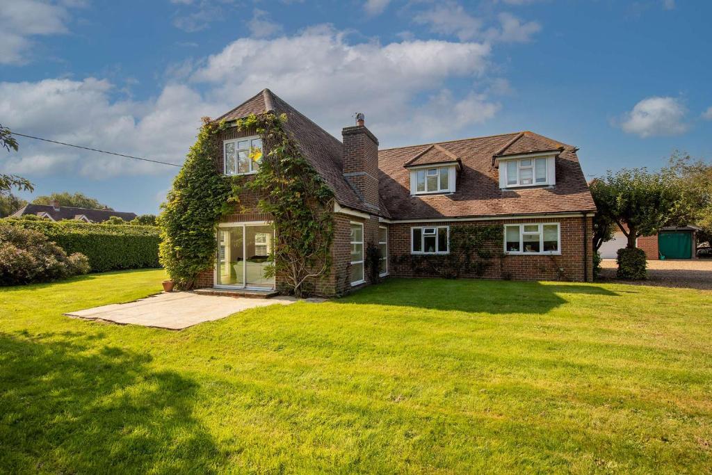 a house with ivy growing on the side of it at Secluded rural retreat close to beach - sleeps 12 in Earnley