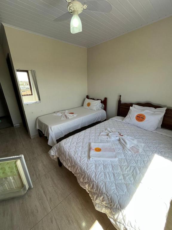 a bedroom with two beds and a ceiling at RESTAURANTE POUSADA E ESCUNA RIO SOl in São João da Barra