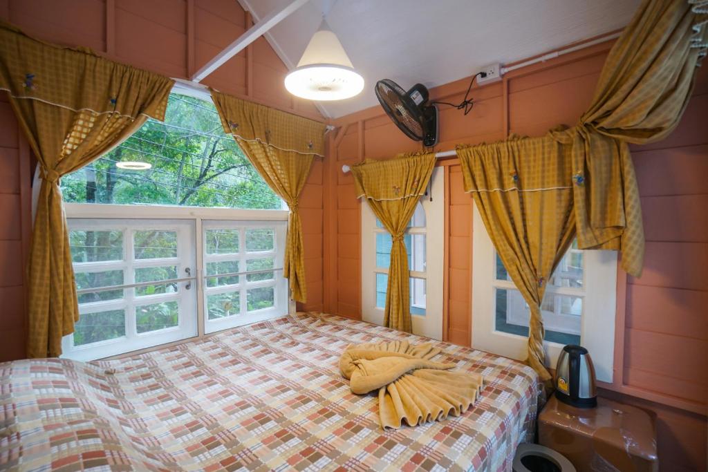 un dormitorio con una cama y una ventana en ปางสูงเฮาส์ pink house, en Ban Pang Bo Hu Bon