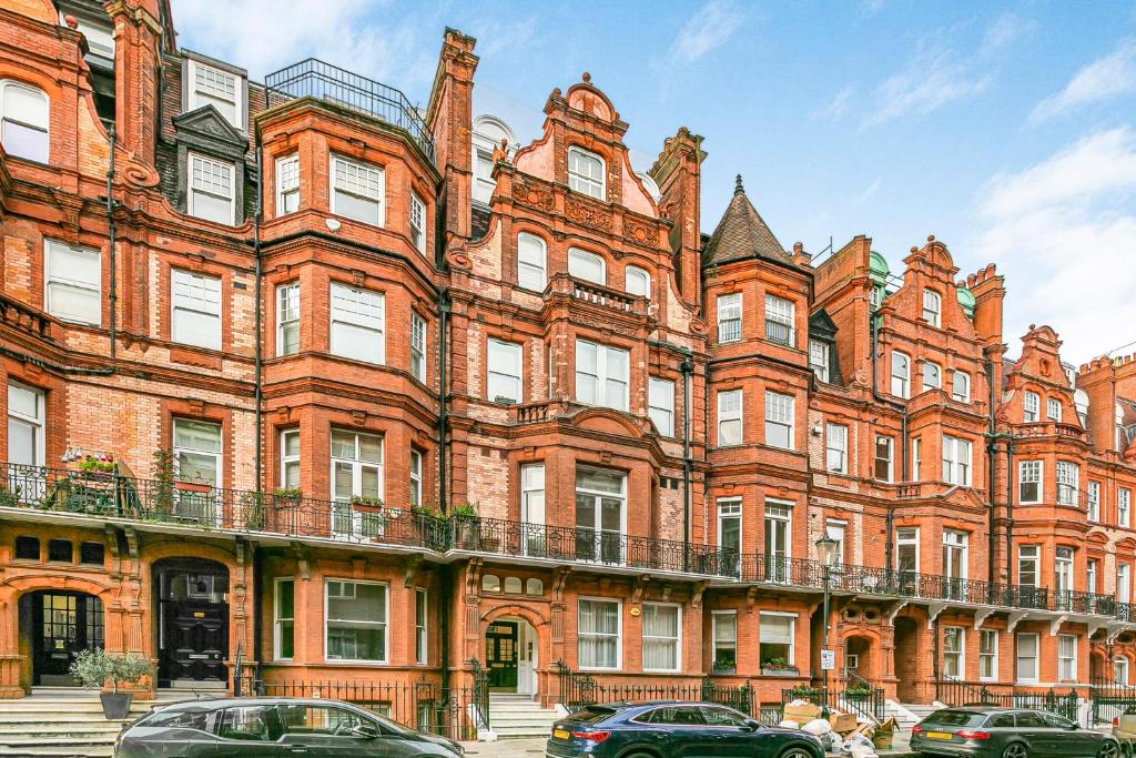 een groot gebouw van rode baksteen met auto's voor de deur bij Security House in Londen