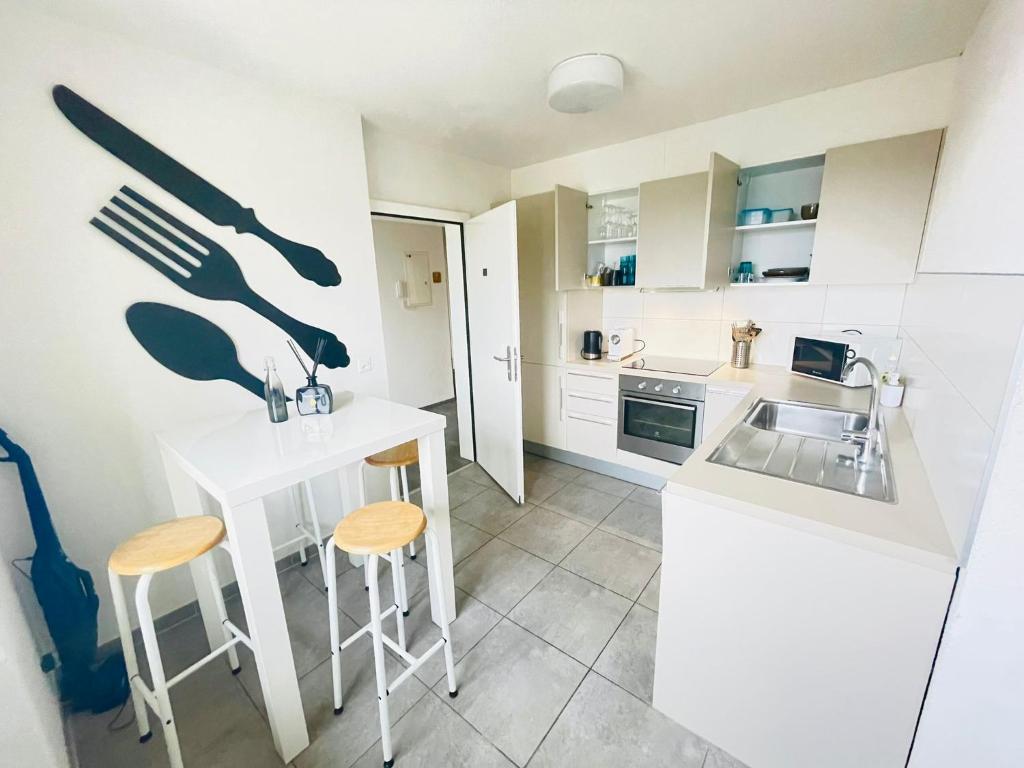 una cucina con bancone, sgabelli e lavandino di The5Continents III - Youth Hostel by Stay Swiss a Porrentruy