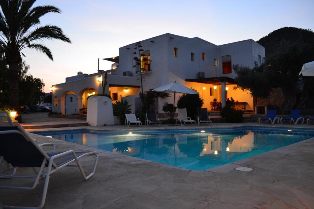 une villa avec une piscine en face d'une maison dans l'établissement Can Luc, à Ibiza