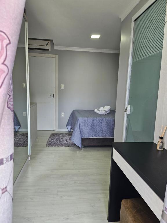a small bedroom with a bed and a bathroom at Família sperandio in Balneário Camboriú