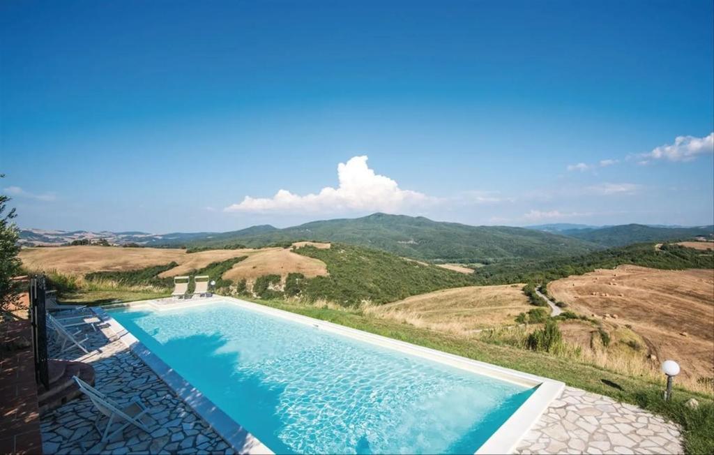 a swimming pool with a view of a mountain at Serene Retreat Apt with Pool & Breathtaking Views in Volterra