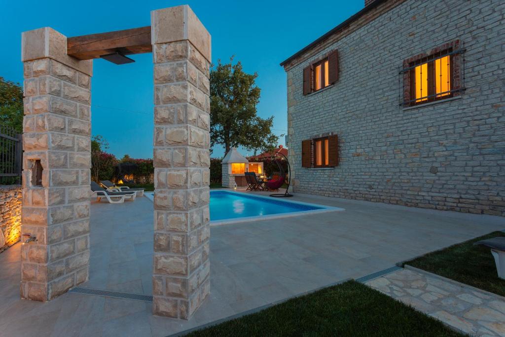 a stone house with a swimming pool in a yard at Villa La Vita in Čabrunići