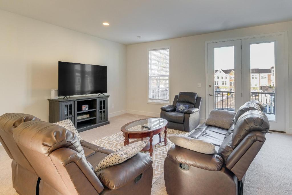 a living room with leather furniture and a flat screen tv at Balcony and Pool Access Modern Gainesville Home in Gainesville