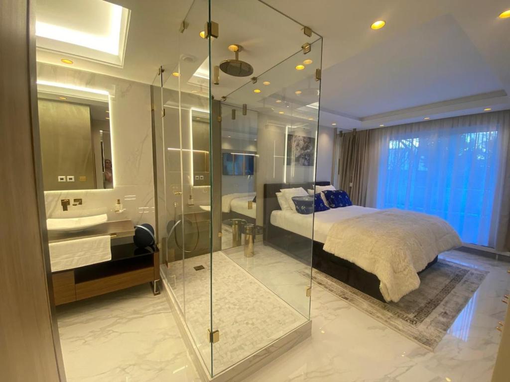 une chambre avec une douche en verre et un lit dans l'établissement Luxury Flat Paris 16 Tour Eiffel, à Paris