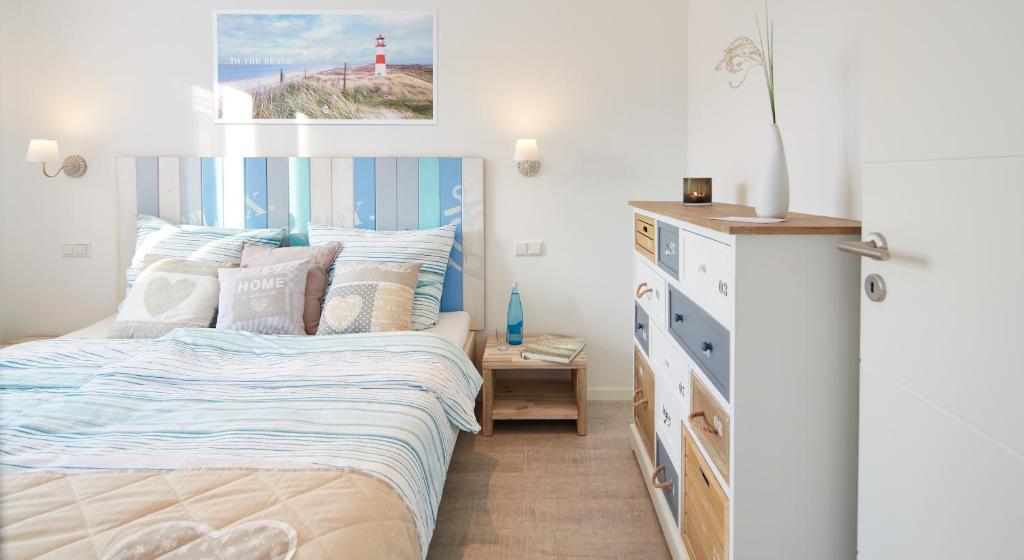 a bedroom with a bed and a dresser and a lighthouse at SK Apartments -Apartment mit 2 Schlafzimmern in Rust