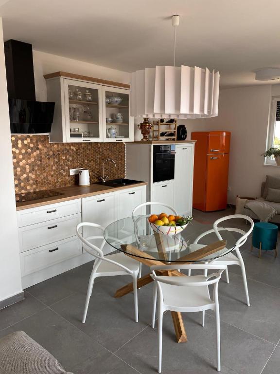 a kitchen with a glass table and white cabinets at Clear Water Apartment - Seaside in Mandre
