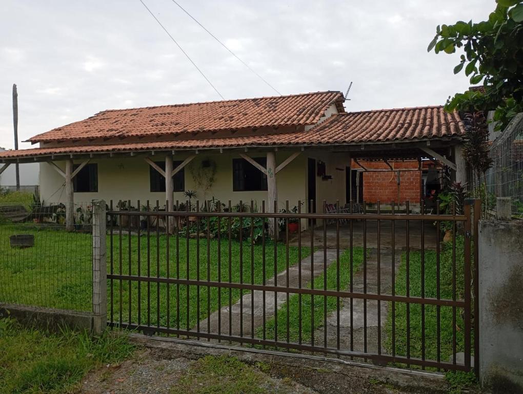 a house with a iron fence in front of it at Casa Amarela in São Francisco do Sul