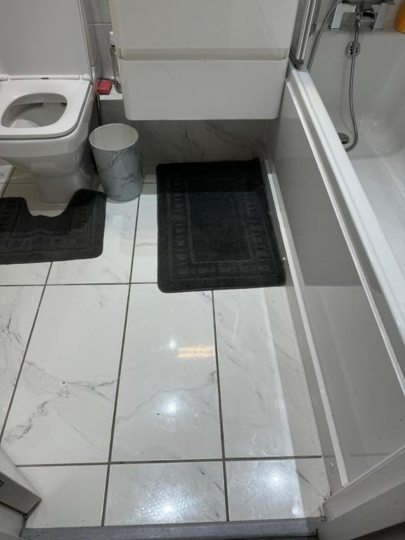 baño con aseo y suelo de baldosa. en The City Glasgow, en Glasgow