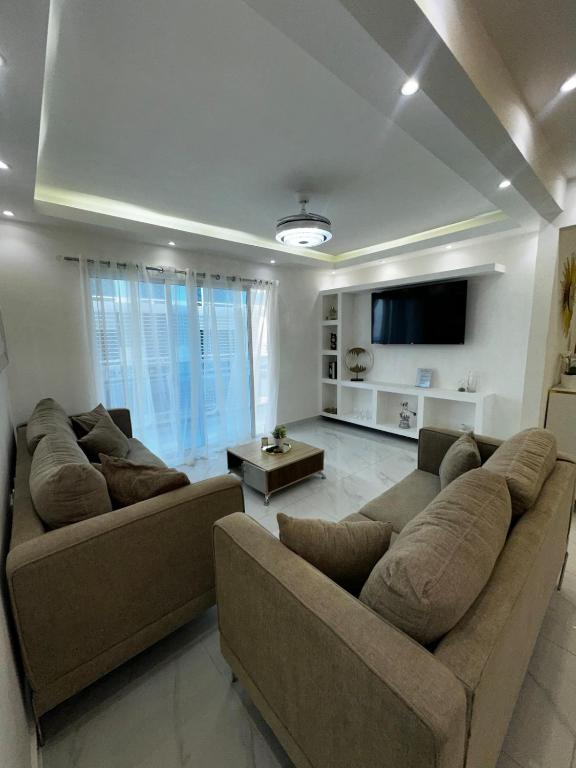 a living room with two couches and a flat screen tv at Santo Domingo Este Stylish Condo in San Isidro