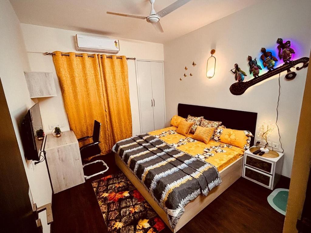 a bedroom with a bed with an orange curtain at Marigold-Luxury Studio in Noida