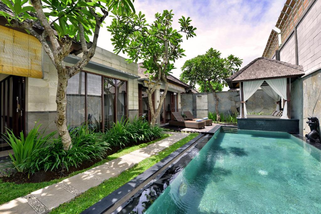 a swimming pool in front of a house at The Khayangan Dreams Villa, Seminyak in Seminyak