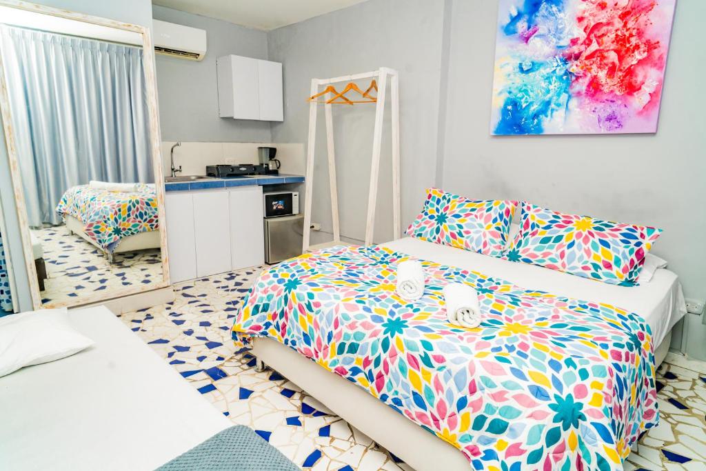 a small room with a bed and a kitchen at Mini departamento a una cuadra de la playa y de la bahia de Bocagrande in Cartagena de Indias