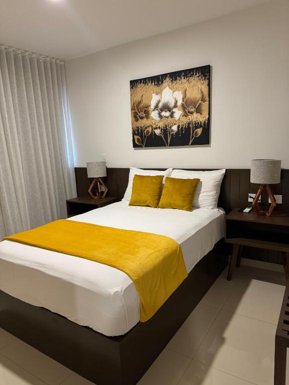 um quarto com uma cama grande e um cobertor amarelo em Hotel Faava em Mazatlán