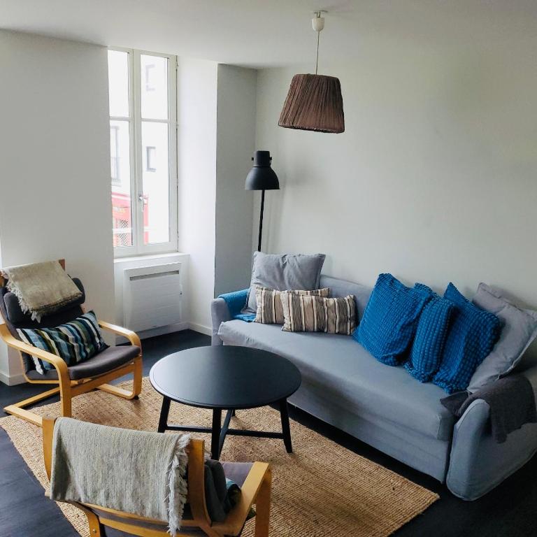un salon avec un canapé bleu et une table dans l'établissement Les Halles 1, à La Rochelle